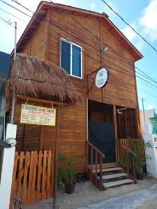 un pequeño edificio de madera con un cartel en Cabañas Chac Mool en Holbox Island