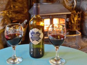 a bottle of wine and two glasses on a table at Tremfor - HW7497 in Llwyngwril