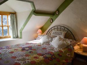 a bedroom with a bed with a colorful bedspread at Tremfor - HW7497 in Llwyngwril