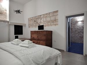 a white bedroom with a bed with towels on it at Villa con piscina mozzafiato, giardino e barbecue in Polignano a Mare +27 photos
