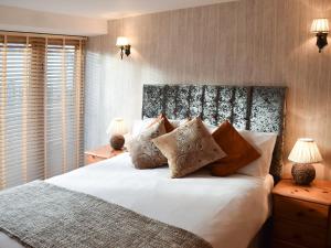 a bedroom with a large white bed with pillows at Barn Owl in Ipplepen