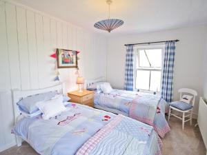 1 dormitorio con 2 camas y ventana en Greenbank Cottage en Hilgay
