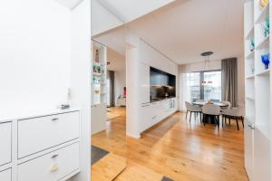 eine Küche und ein Esszimmer mit weißen Schränken und einem Esstisch in der Unterkunft Spacious apartment with terrace and grarage in Pärnu
