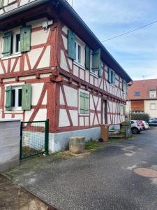 a half timbered building with green shutters on it at Le cinéma in Soultz-sous-Forêts