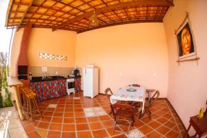 a kitchen and dining room with a table and a refrigerator at Vila Nina in São Miguel do Gostoso