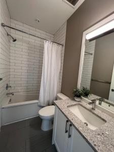 a bathroom with a toilet and a tub and a sink at Abacus Zen by IRIS PROPERTIES! in Victoria