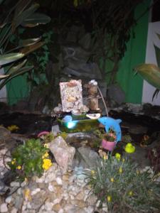 un jardín en miniatura con una casa y algunas plantas en Residencial Susy, en Bombinhas