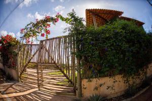 a fence with a bunch of flowers on it at Vila Nina in São Miguel do Gostoso