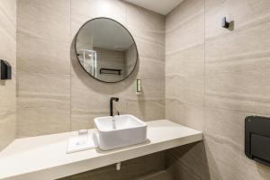 a bathroom with a sink and a mirror at Ventimo Hotel & Residence Jeju in Jeju