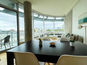 un soggiorno con tavolo, sedie e una grande finestra di Janion Oasis by IRIS PROPERTIES! a Victoria