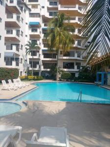 una piscina frente a un gran edificio de apartamentos en Edificio Arrecifes, La vida es mejor frente al mar, en Santa Marta