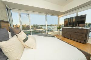 een slaapkamer met een groot bed en een groot raam bij Janion Sky by IRIS PROPERTIES! in Victoria