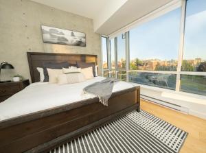 een slaapkamer met een groot bed en een groot raam bij Janion Sky by IRIS PROPERTIES! in Victoria