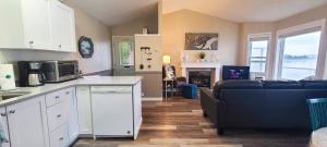 a kitchen and a living room with a couch at Seascape Beach House by IRIS PROPERTIES! in Sooke