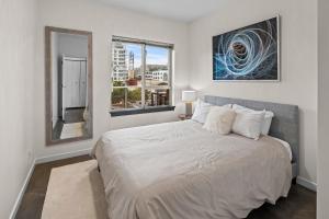 een witte slaapkamer met een groot bed en een raam bij Soho Penthouse by IRIS PROPERTIES! in Victoria