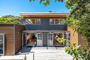 a modern house with a wooden front porch at Inside Out House in Oneroa