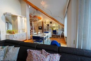 uma sala de estar com um sofá e uma sala de jantar em Große, helle Wohnung für bis zu 6 Personen em Weinheim