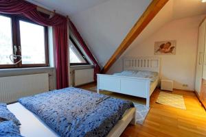 a bedroom with two beds and two windows at Große, helle Wohnung für bis zu 6 Personen in Weinheim