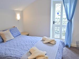 a bedroom with a blue bed with towels on it at The Old Stable in West Pennard