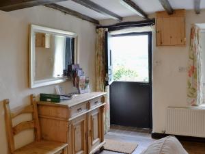 a room with a wooden dresser and a window at Crogen Bryn Awel in Llandrillo