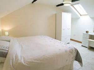 a white bedroom with a bed and a ceiling at Meadow Cottage in Westward