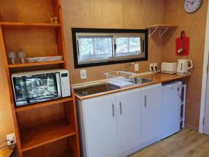 a small kitchen with a sink and a microwave at Helles, modernes Containerhaus in Punta del Este