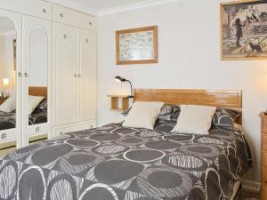 a bedroom with a bed with a black and white comforter at Sea View in Hastings