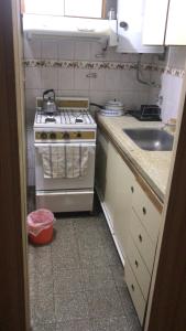 a small kitchen with a stove and a sink at Playa Grande - Alem y Saavedra - Depto apto 7 personas in Mar del Plata