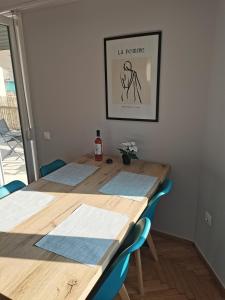 un tavolo con sedie blu e una foto sul muro di Penthouse spacious w super wifi & terrace, 2 min from metro ad Atene