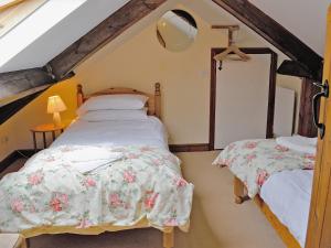een slaapkamer met 2 bedden op een zolder bij The Stables in Ansty
