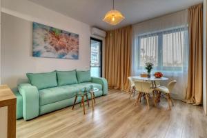a living room with a green couch and a table at Inspiration Station - Modern, Warm&Cosy Apt - Smart Thermostat - Private Parking - IOR Park - Long Term Price Cuts in Bucharest