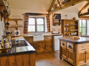 a large kitchen with wooden cabinets and a counter top at The Stables in Ansty