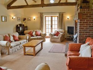 a living room with couches and a brick wall at The Stables in Ansty