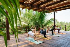 a group of people doing yoga on a deck at Olas Tulum in Tulum