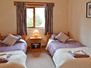 2 camas individuales en una habitación con ventana en The Paddock en Saint Hilary