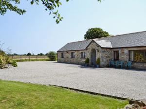 a stone house with chairs in front of it at The Paddock in Saint Hilary