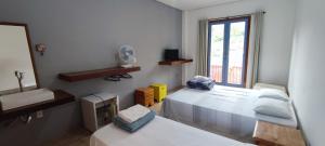 Zimmer mit 2 Betten, einem Spiegel und einem Fenster in der Unterkunft Pousada Santa Maria in Tiradentes + 124 Fotos