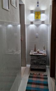 ブジオスにあるcasa com piscina e churrasqueira adoravelのバスルーム(シャワー、ドレッサー、ラグ付)が備わります。