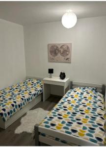 een slaapkamer met 2 bedden en een tafel met een bureau bij Chez mimi in Toulouse