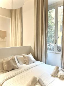 um quarto com uma grande cama branca e uma janela em Divini Gae Aulenti em Milão