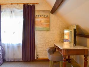 een slaapkamer met een houten bureau en een raam bij Mill Batch Cottage in Mark