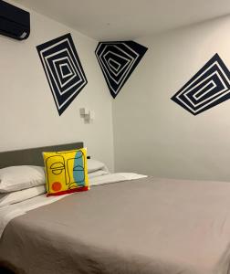 a bed with a yellow and blue pillow on it at THUISHAVEN boutique mini-resort - fantastic garden and large pool - adults only in Willemstad
