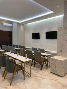 a conference room with tables and chairs and televisions at ZEGEN HOTELS LagosdeMoreno in Lagos de Moreno