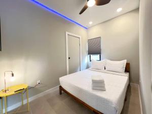 - une chambre avec un lit et une table jaune dans l'établissement Apartment 2BD 1BR CalleOcho Brickell Downtow Beach 15 min A, à Miami