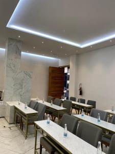 a conference room with tables and chairs and a white wall at ZEGEN HOTELS LagosdeMoreno in Lagos de Moreno