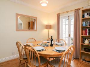 a dining room with a wooden table and chairs at Louisa Cottage in Weymouth