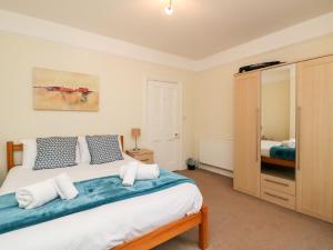 a bedroom with a large bed with blue and white pillows at Louisa Cottage in Weymouth