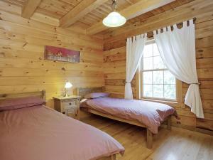 MiningsbyにあるKingfisher Lodge - E4159aのログキャビン内のベッドルーム1室(ベッド2台付)