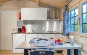 a kitchen with white cabinets and a table with food on it at Beautiful Home In Heinkenszand With Outdoor Swimming Pool in Heinkensand