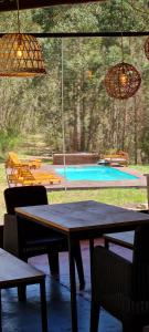 un patio con mesa y sillas y una piscina en EL BOSQUE DE LAS ANIMAS en Tandil